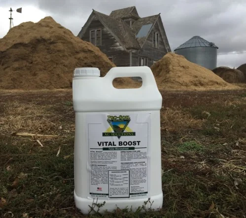 Triple 3 Vital Boost jug in front of a farmhouse
